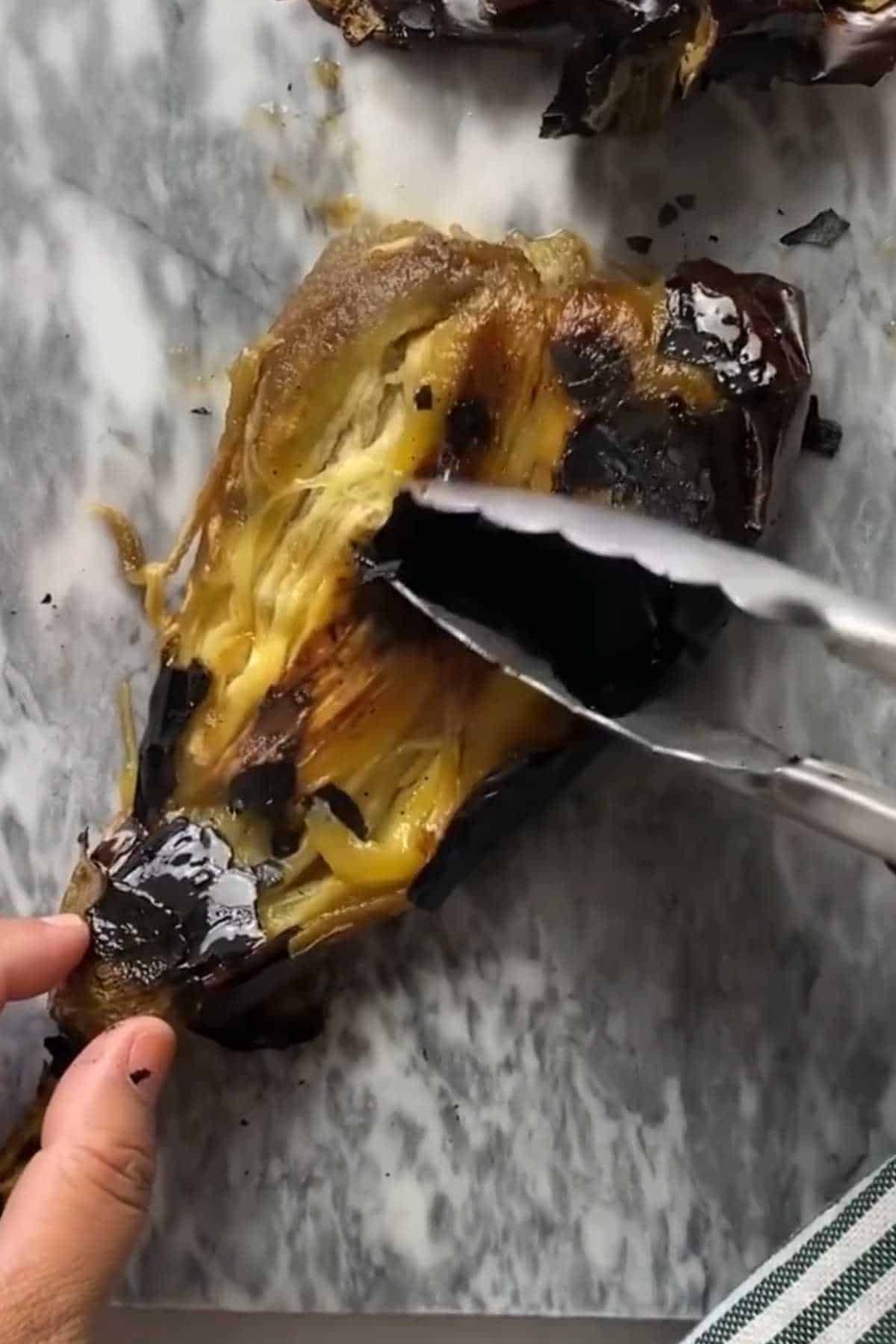 Peeling the charred skin from roated eggplant.