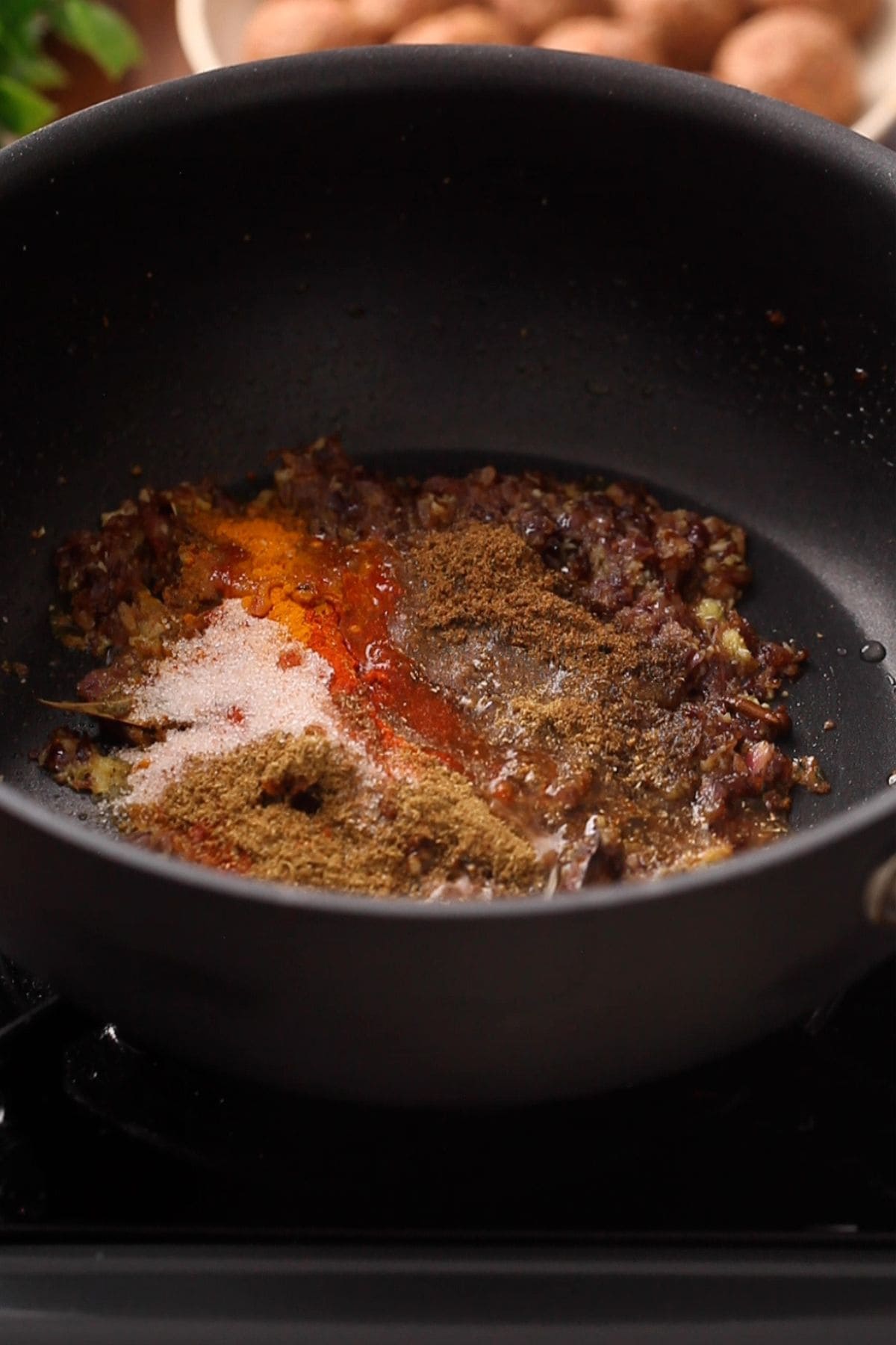 Ground spices are added to browned onions.