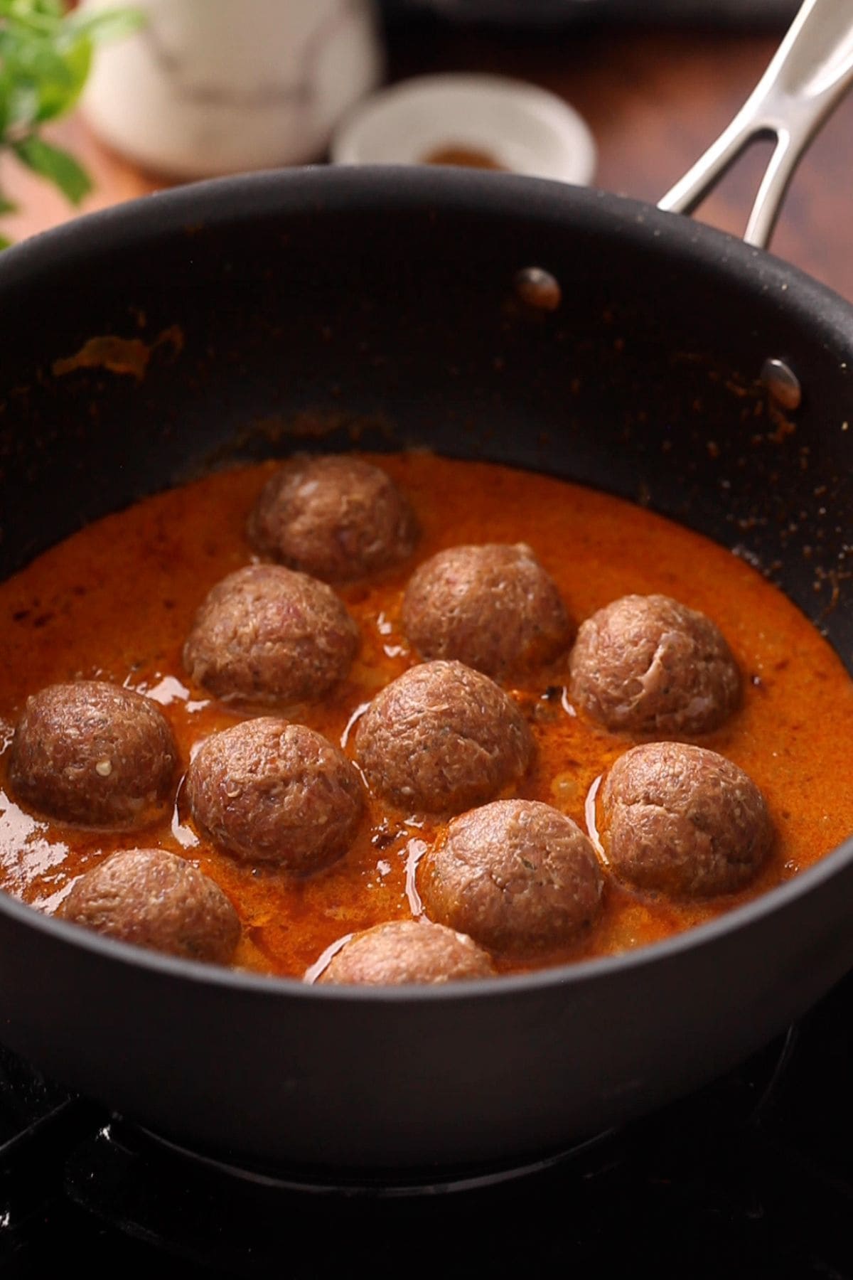 Raw kofta are placed in a single layer in the gravy.