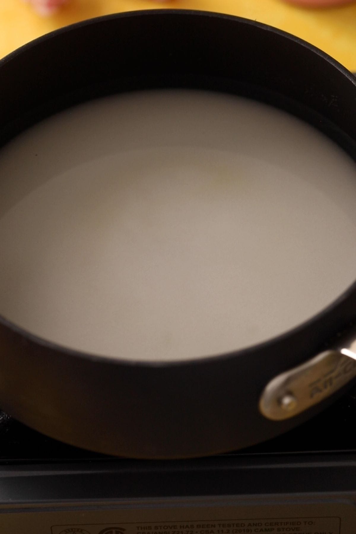 Water and sugar a black pot on stove top.