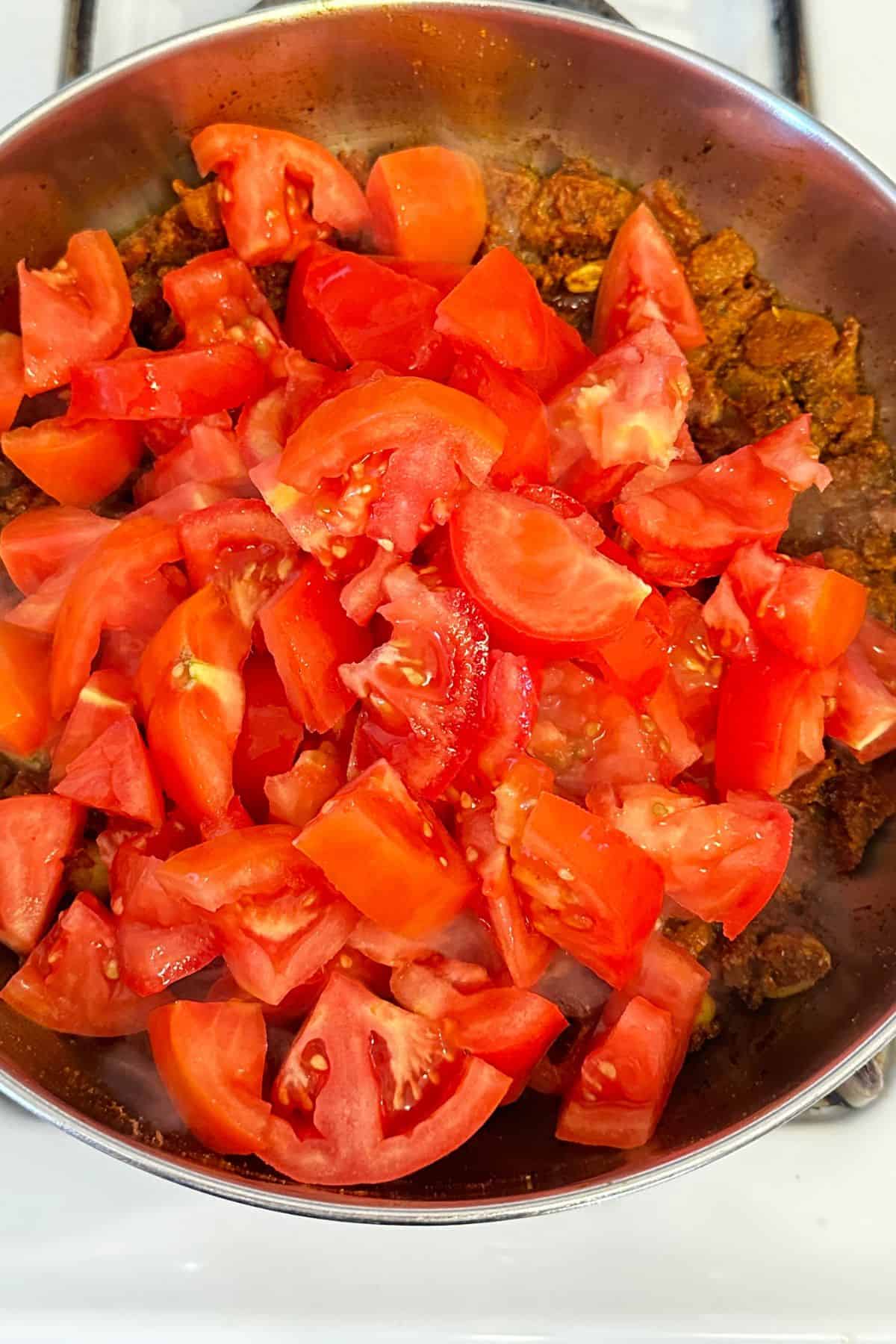 Fresh tomatoes are added to the masala.