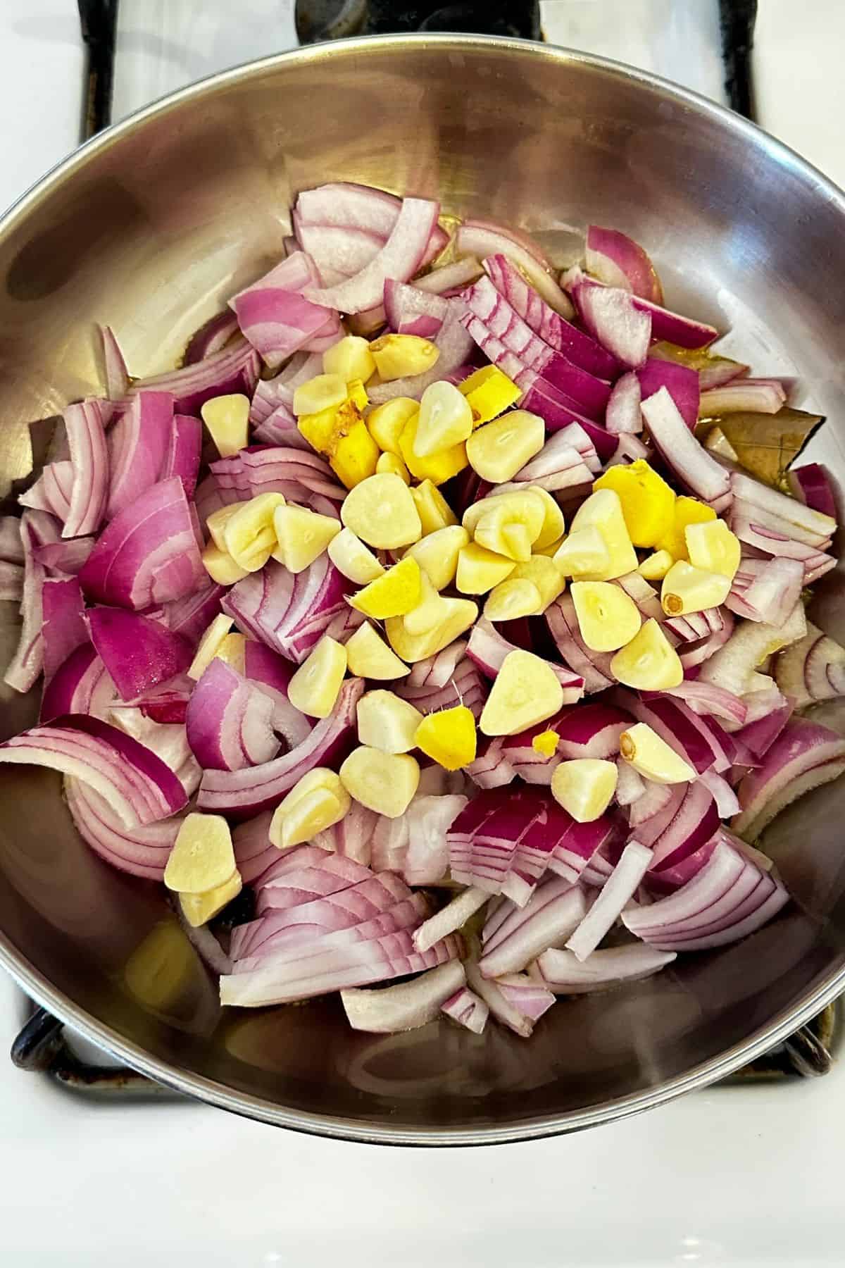 Onion, ginger and garlic are added to the hot oil.
