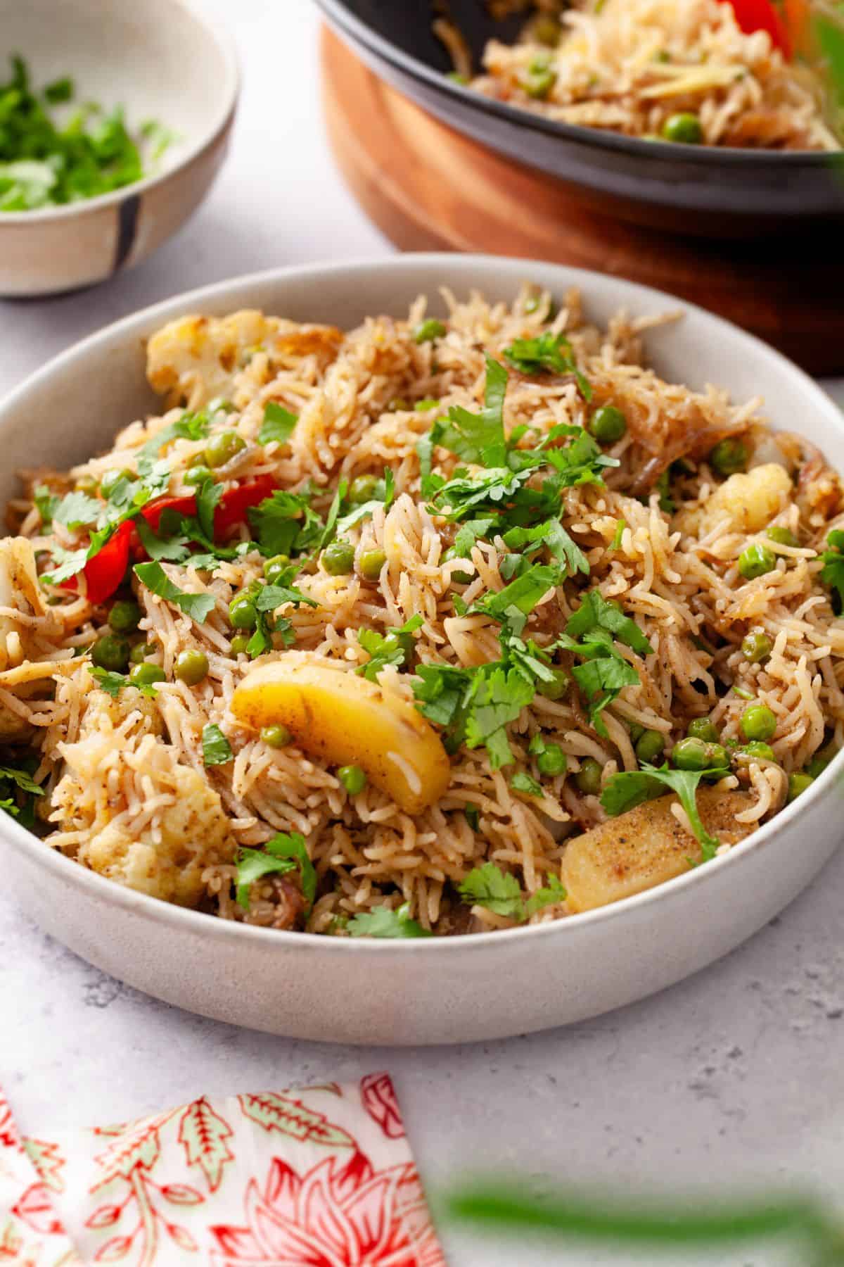 Tahiri plated in a large white stone ware bowl with chopped cilantro in background.