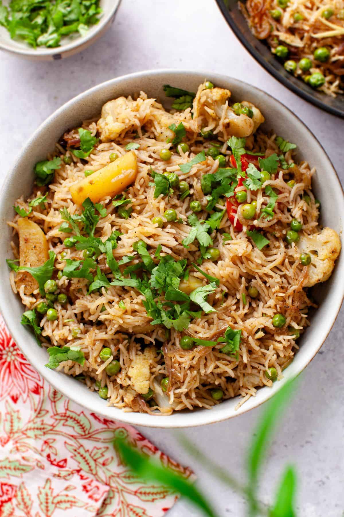 Top view of vegetable tahiri served in a bowl with floral napkin o the side.