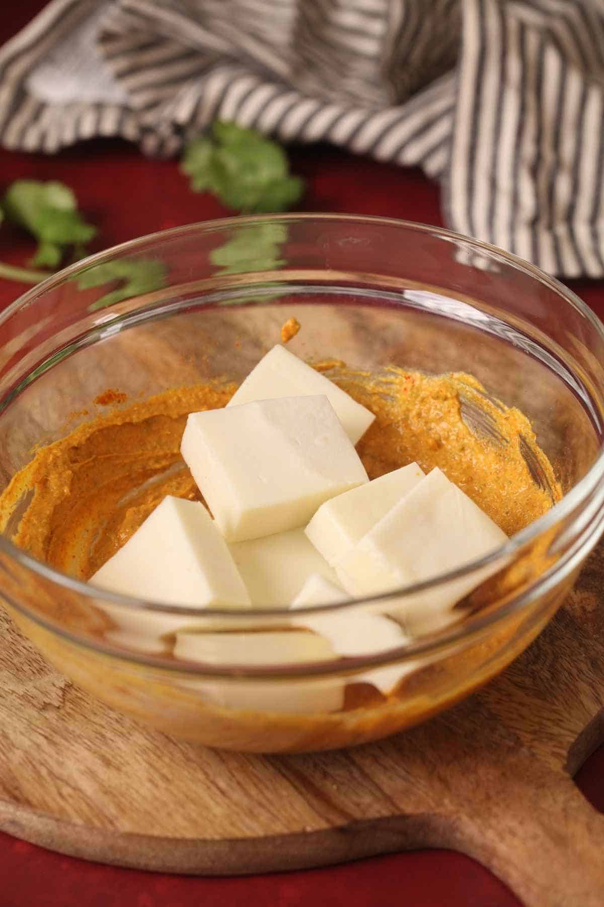 Paneer being mixed with marinade.
