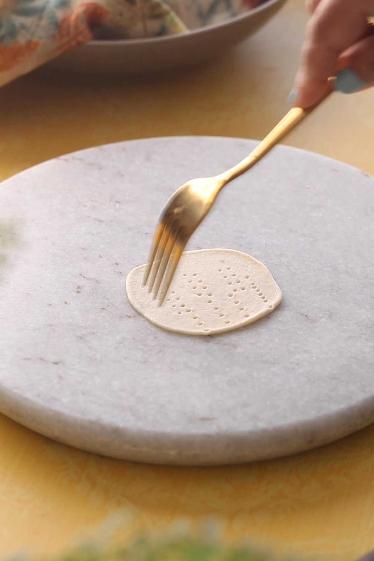 Pricking papri with a gold fork.