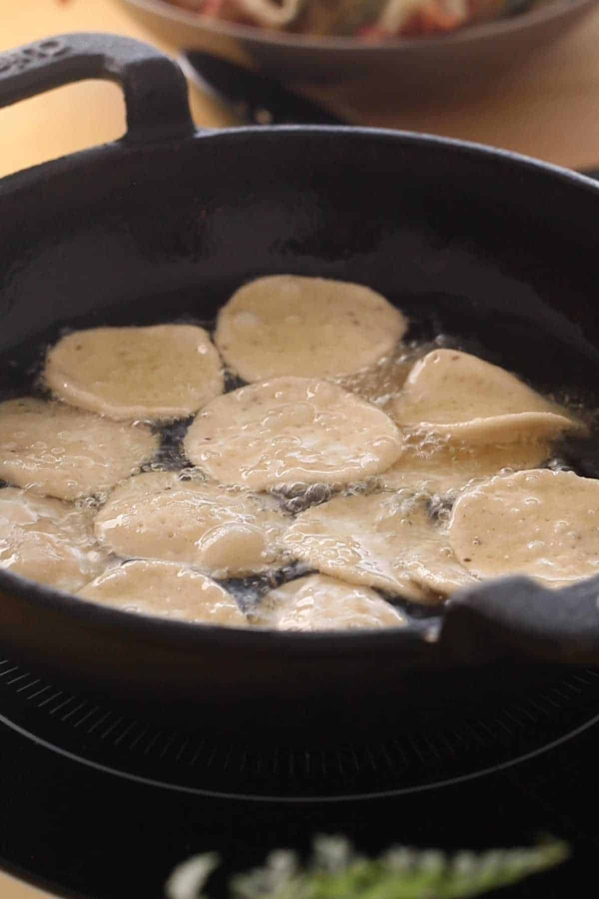 Adding rolled papri to hot oil for browning.