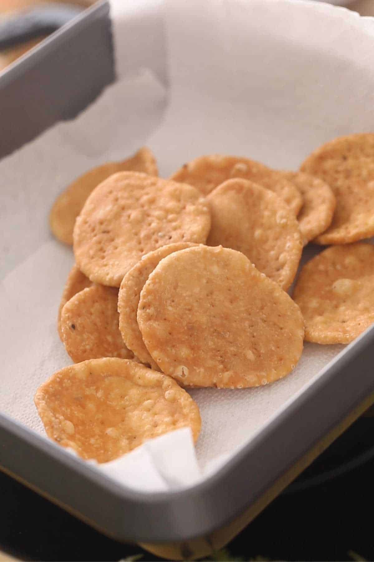 Draining fried papri on a paper towel lined tray.