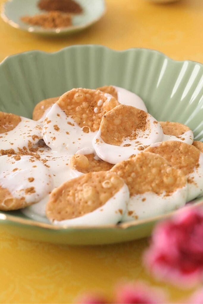 Yogurt dipped papri in a green bowl.