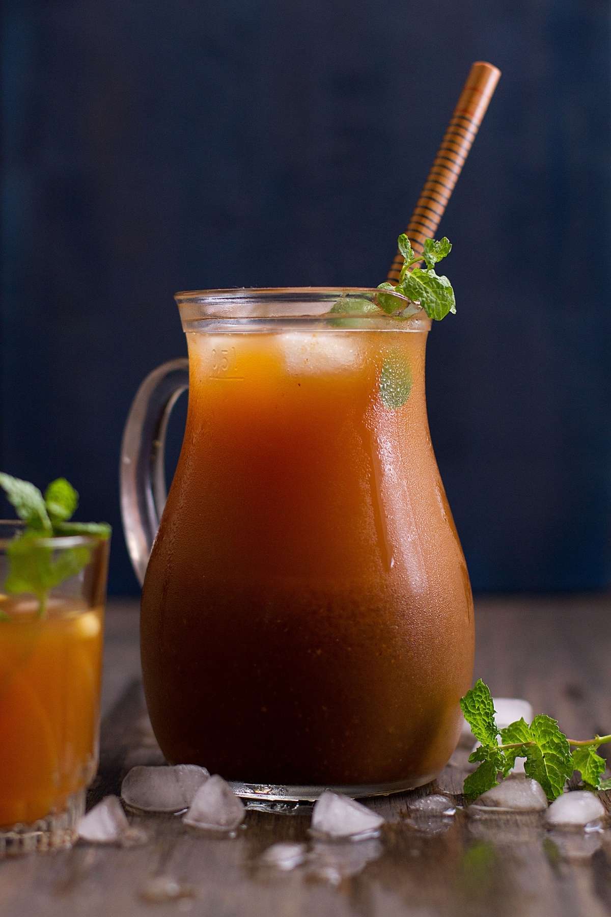Chilled Jaljeera drink served in a large pitcher with ice cubes and mint leaves.