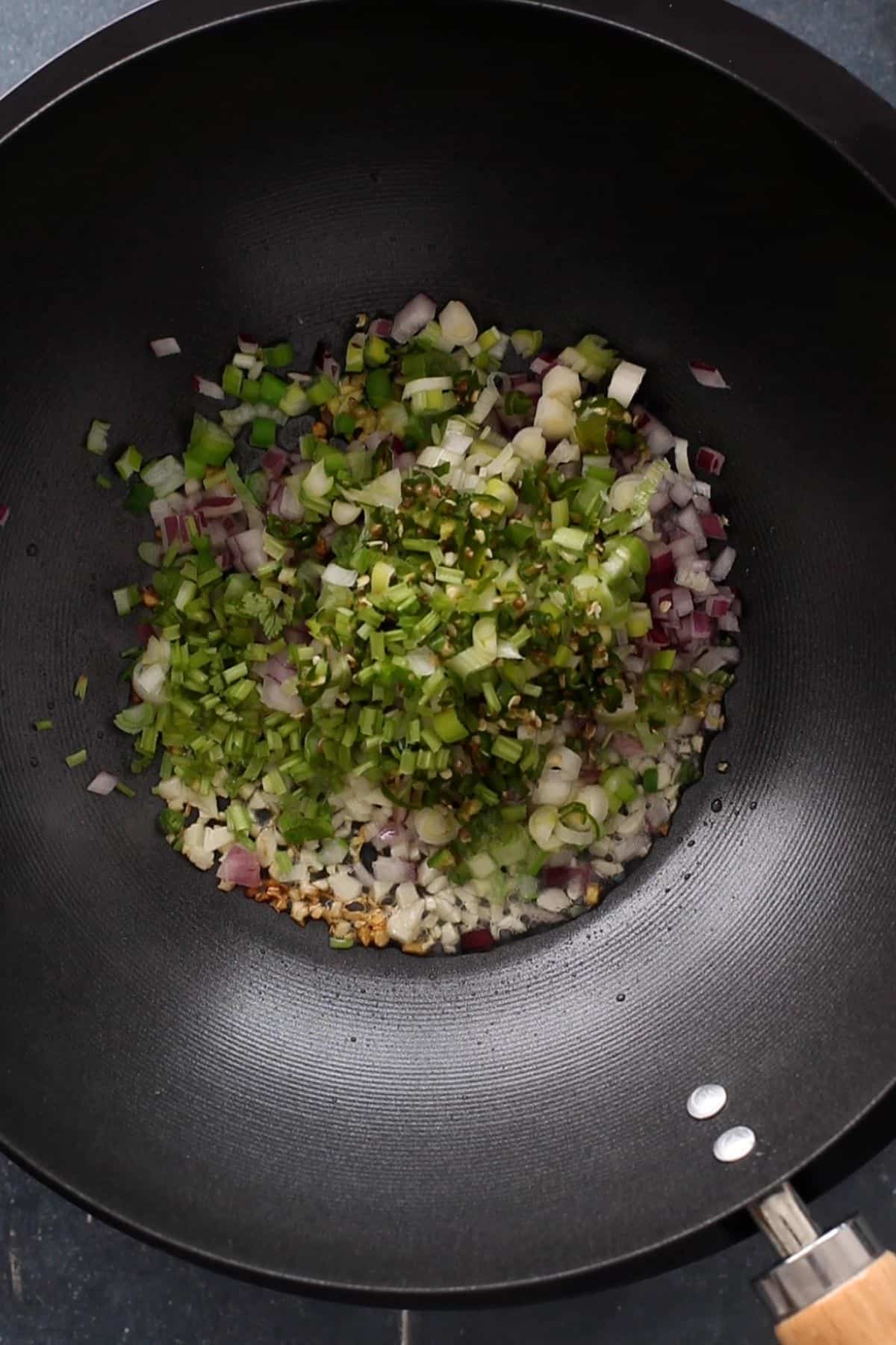 All aromatics are added to a wok.