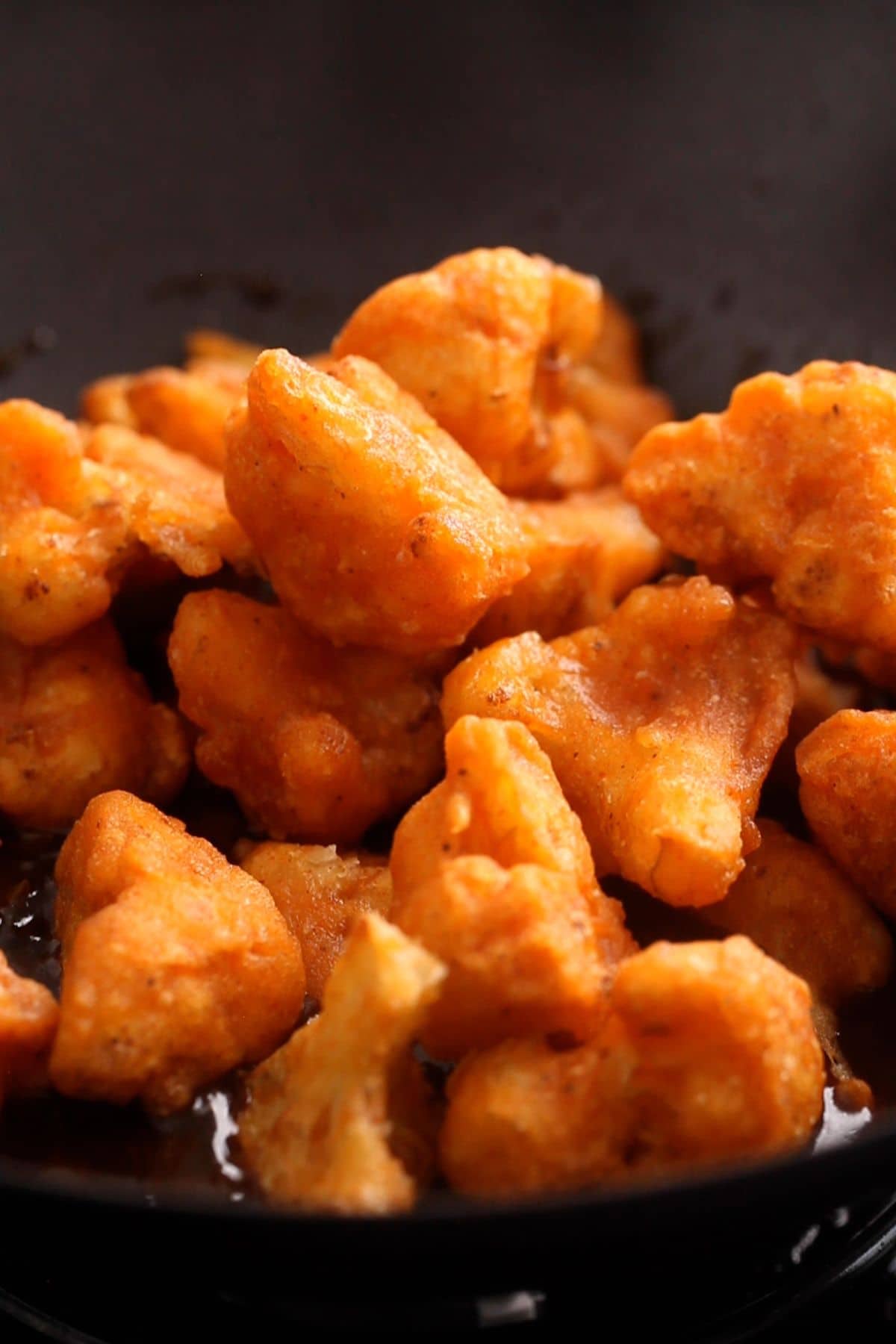 Fried cauliflower are added to manchurian sauce.