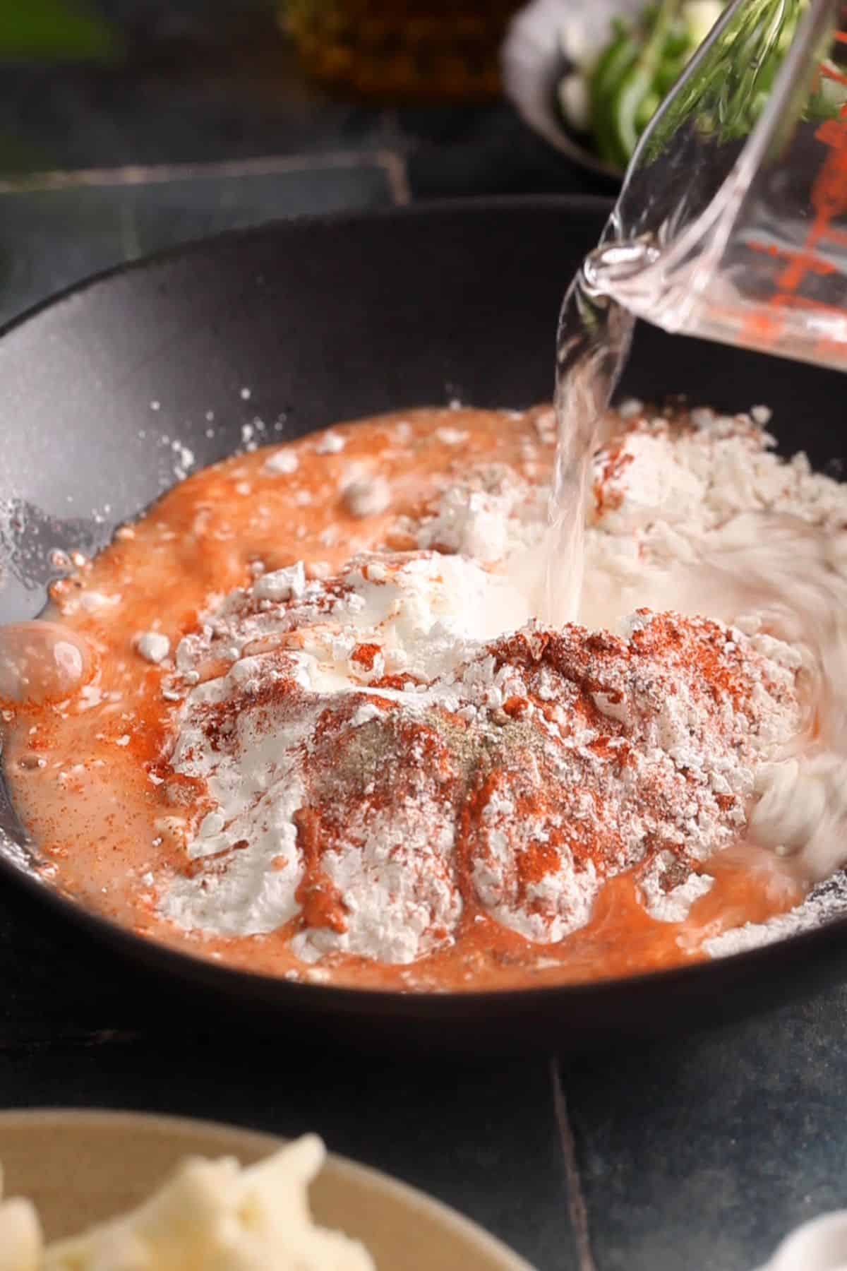 Adding water to make the batter.