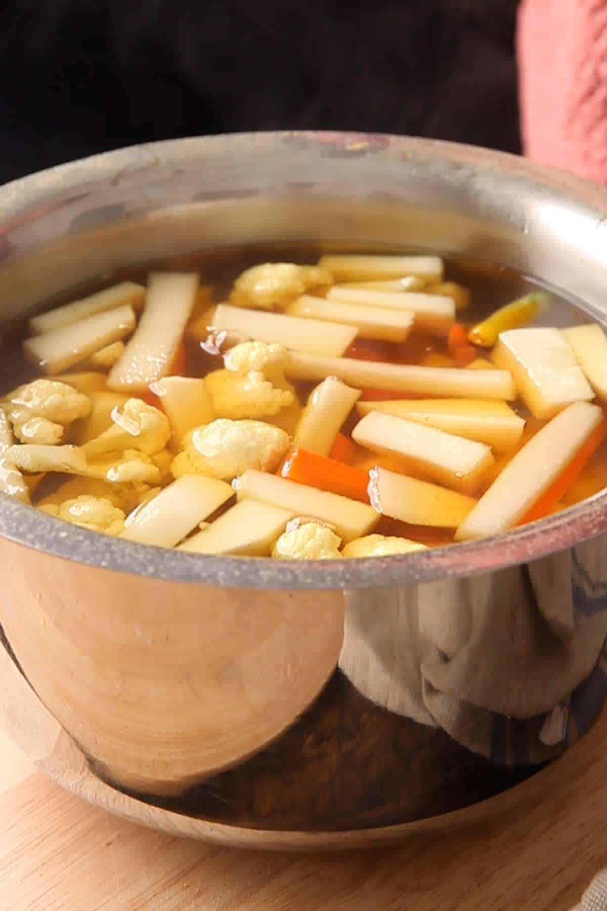 Blanching the vegetables to make pickle.