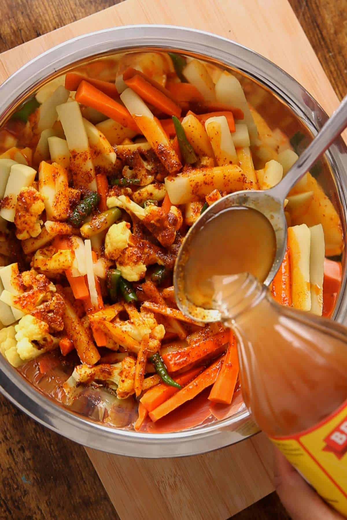 Adding apple cider vinegar to the vegetables.