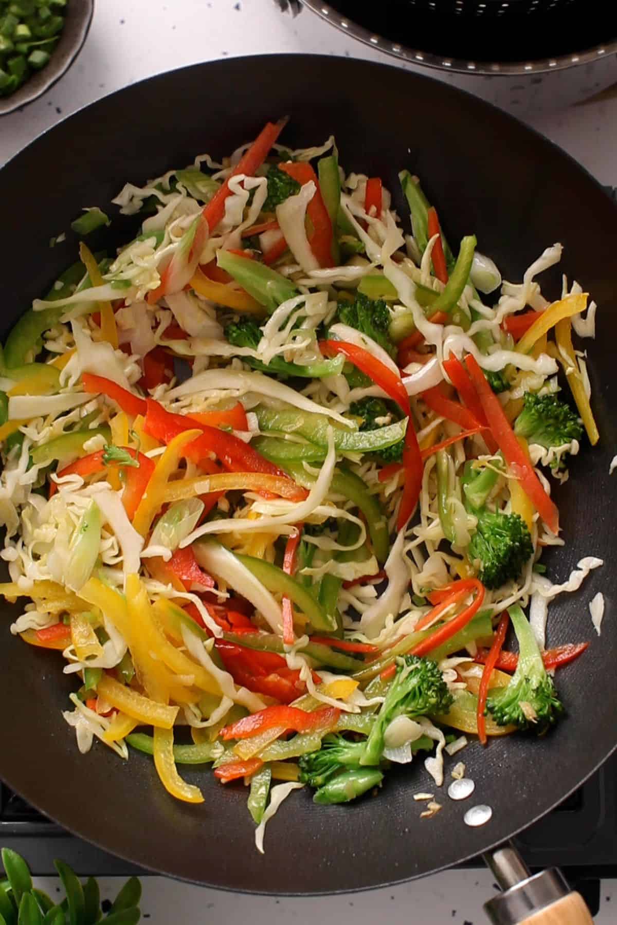 Colorful vegetables are stir frying in the chinese wok.