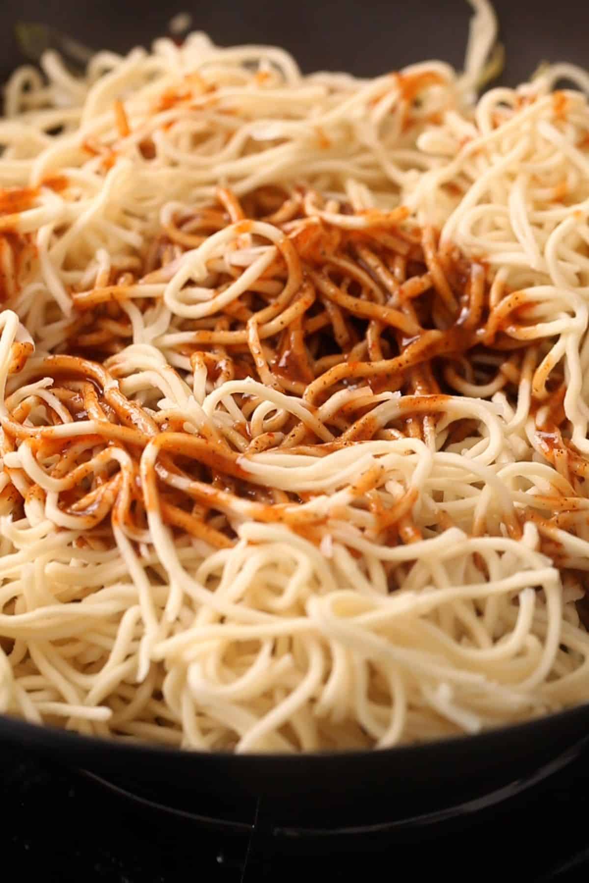 Noodles and sauce are added the wok.