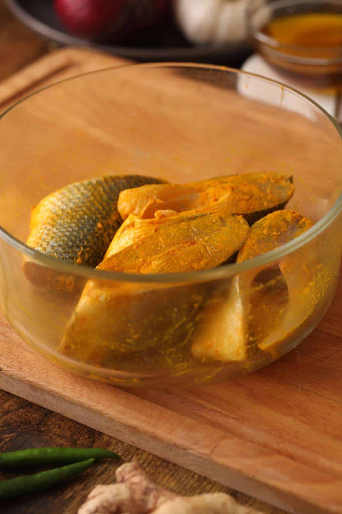 Marinated Fish Steaks with turmeric powder and salt. Placed in a glass bowl. 