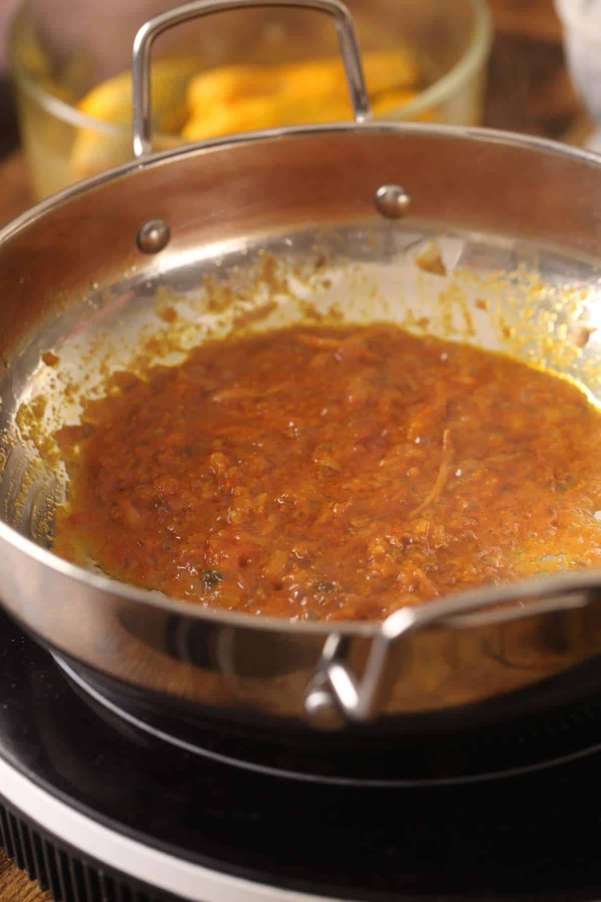 Cooking the masala for making fish curry. 