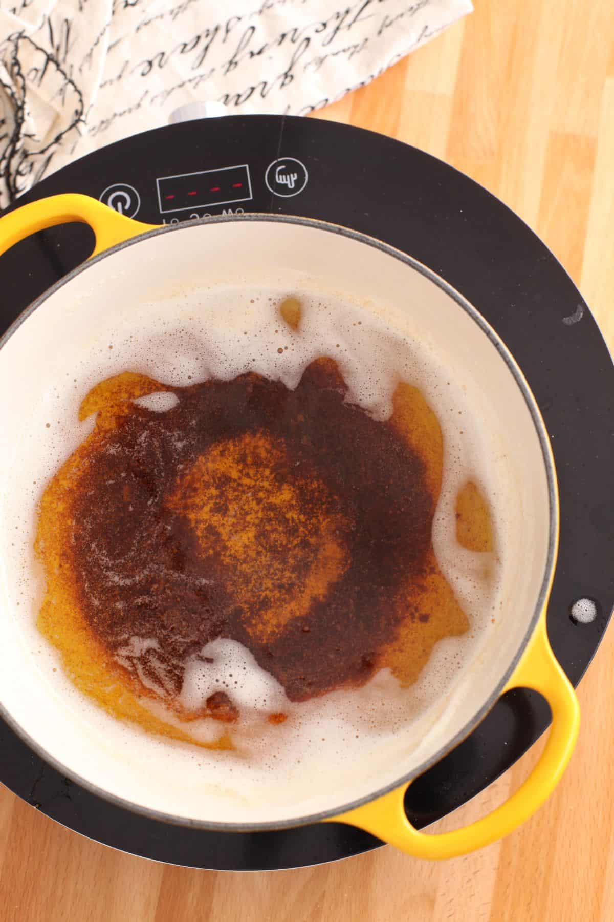 Golden milk solids at the bottom of the pot with a clear ghee layer on top.
