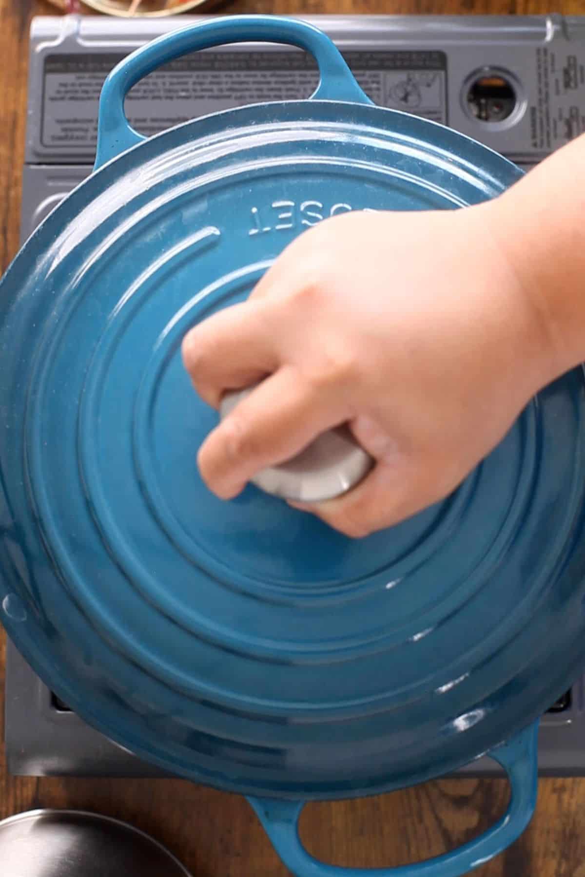 Cooking pot is covered with lid for slow cooking.