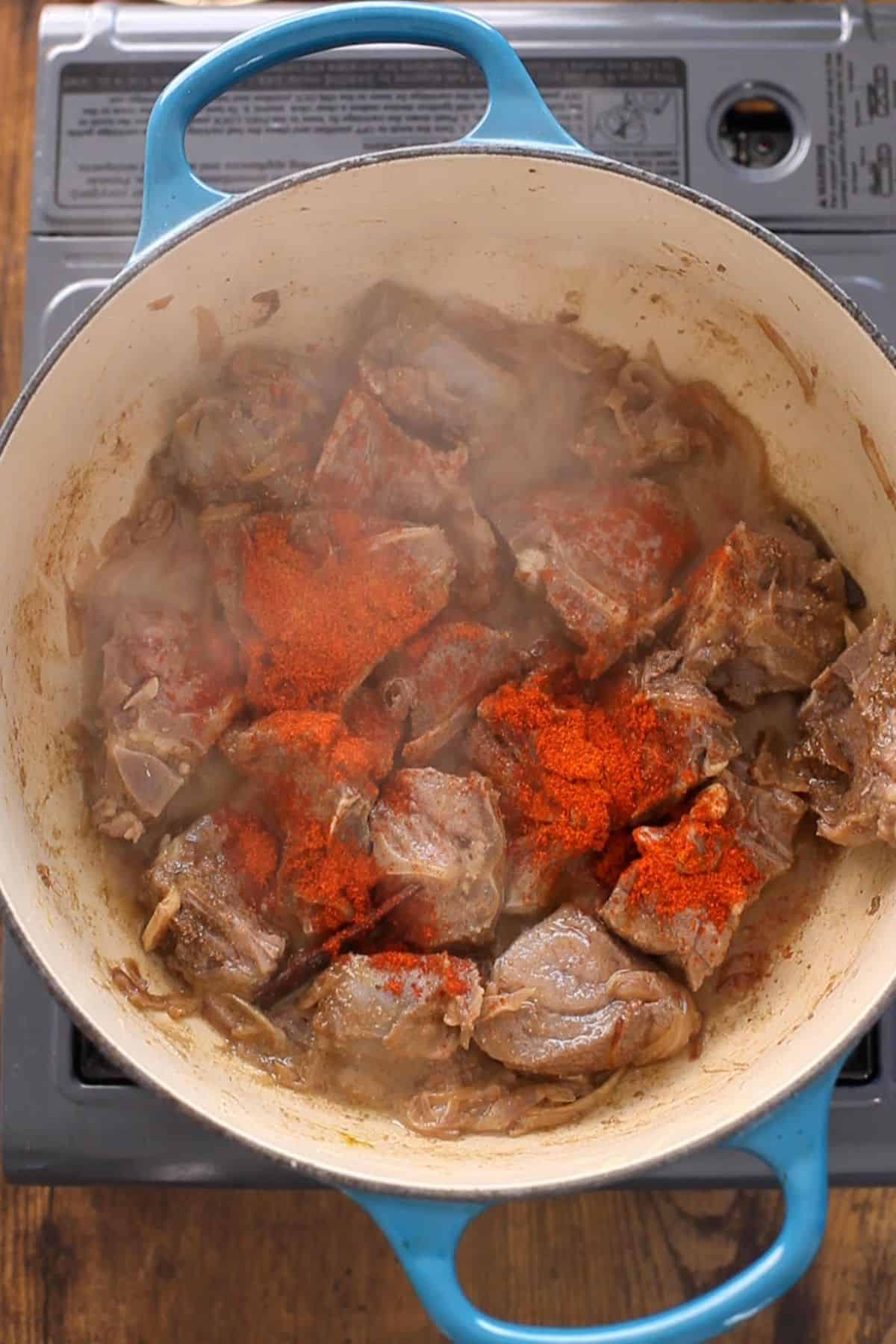 Spice powders are added to the cooking pot.