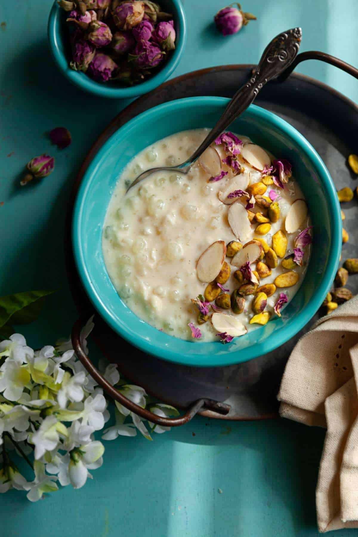 Sabudana Kheer plated in a blue bowl with nut toppings.
