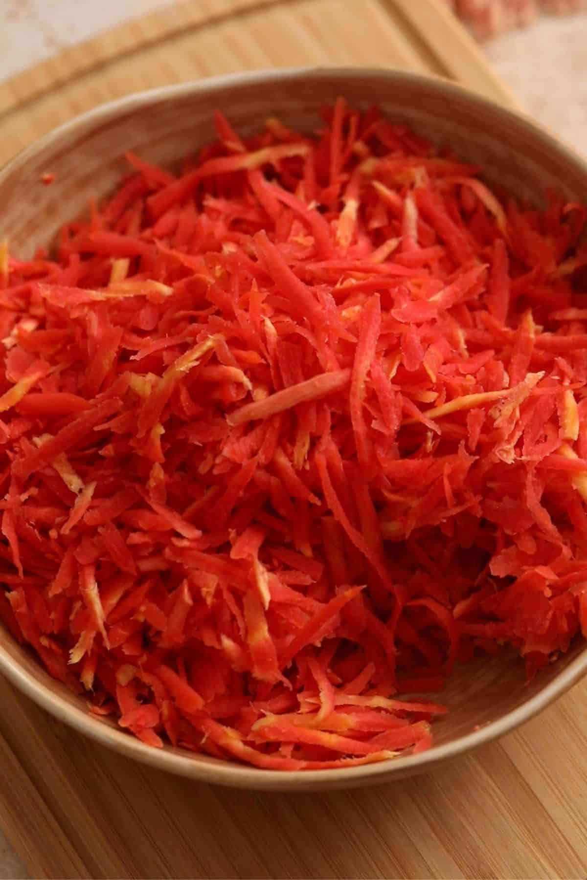 Shredded red carrots placed in the beige brown bow.