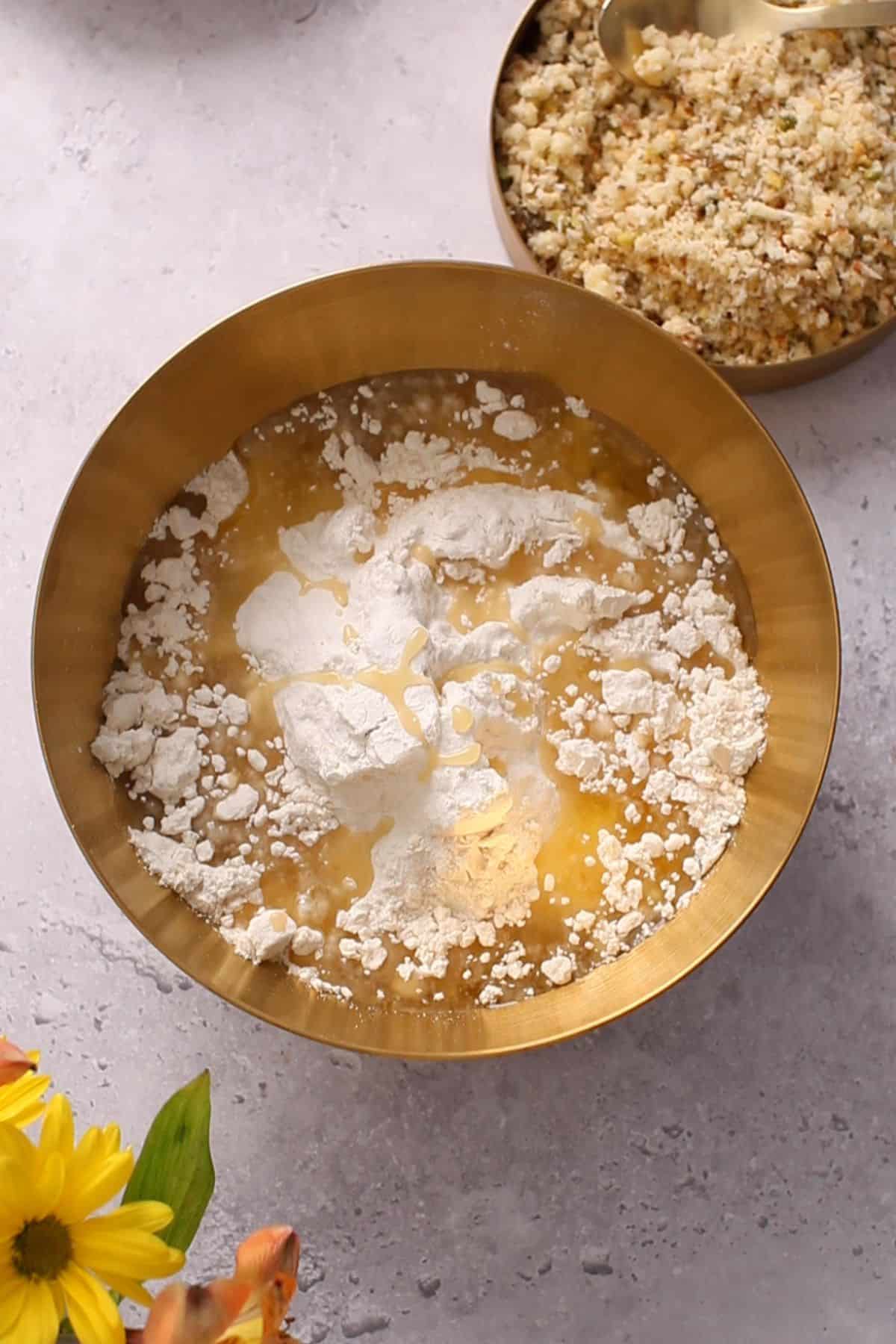 Melted ghee is poured over flour.