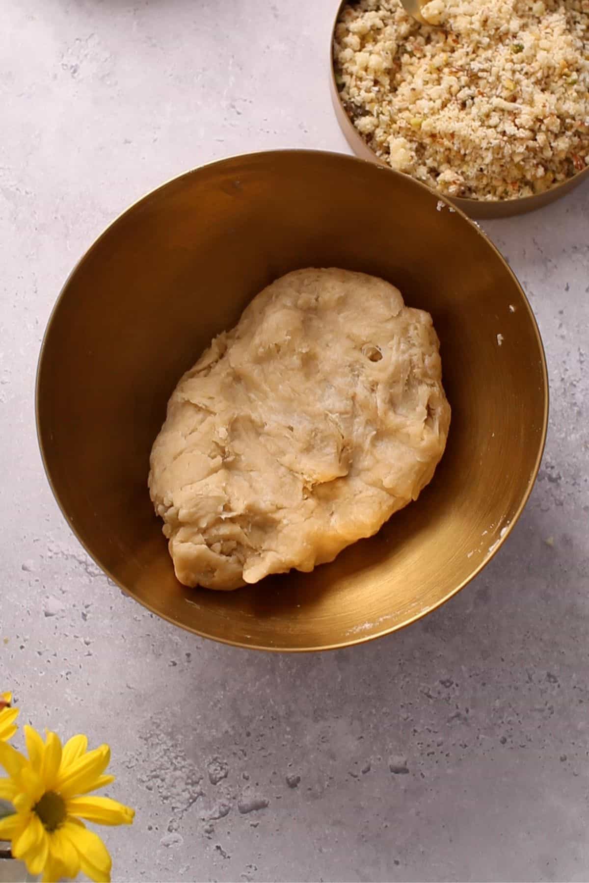 Gujiya dough in a gold mixing bowl.