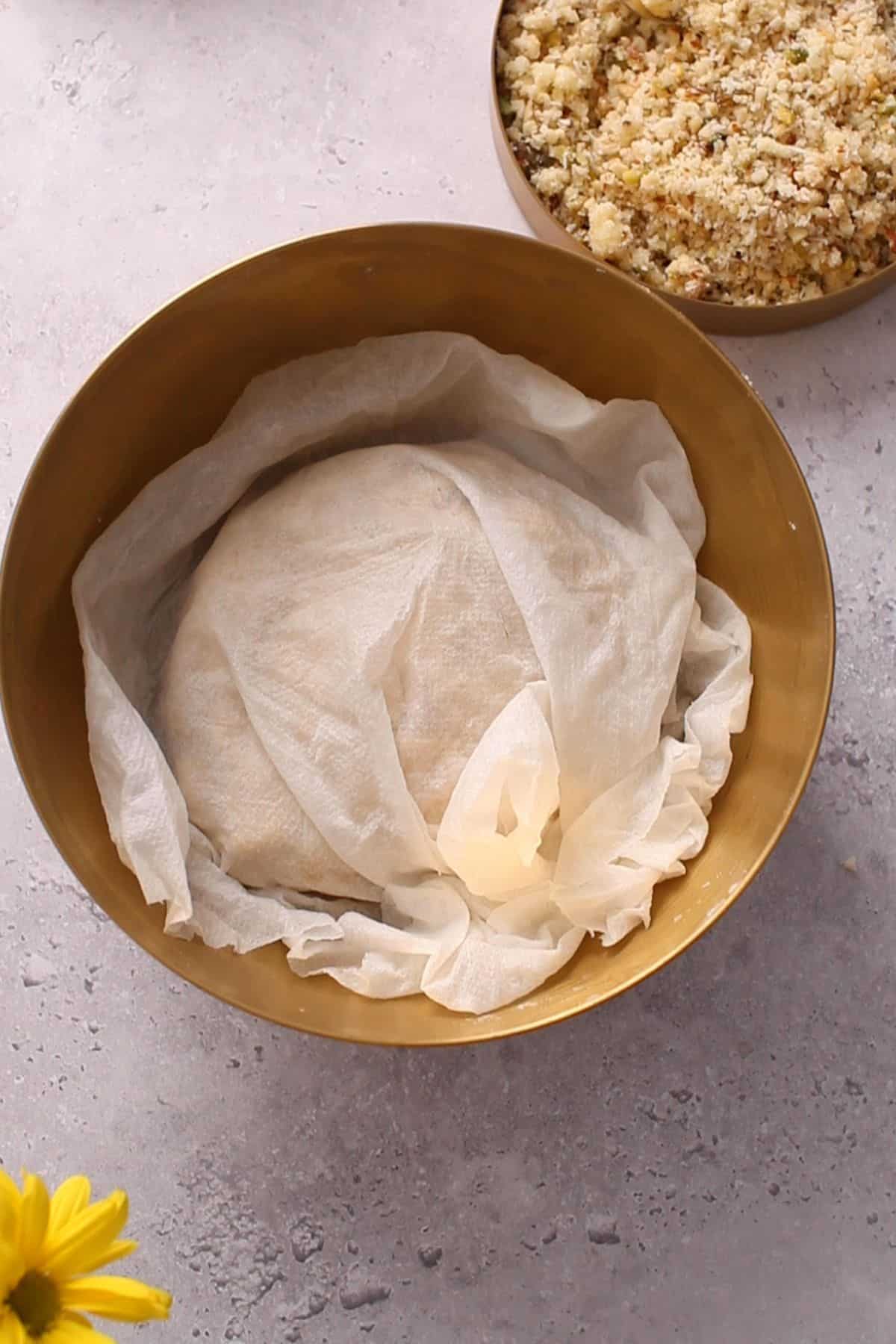 Gujiya dough is covered with a damp paper towel. 