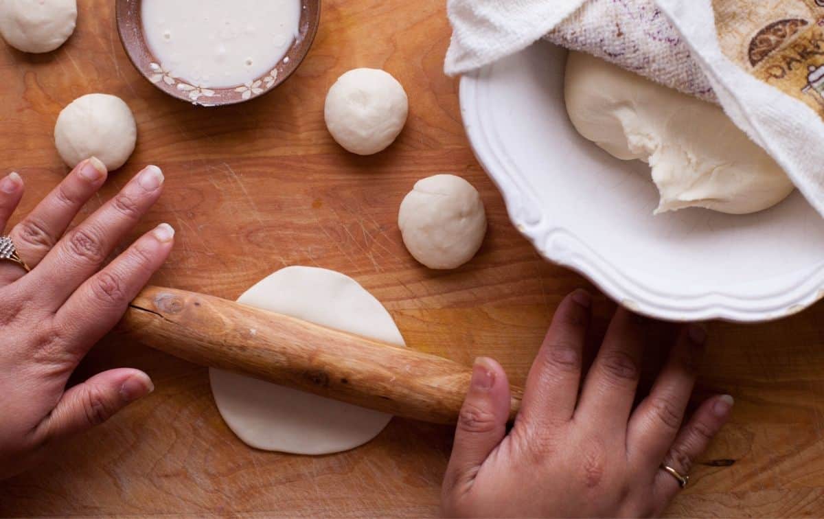 Dough being rolled using rolling pin for making gujiya 