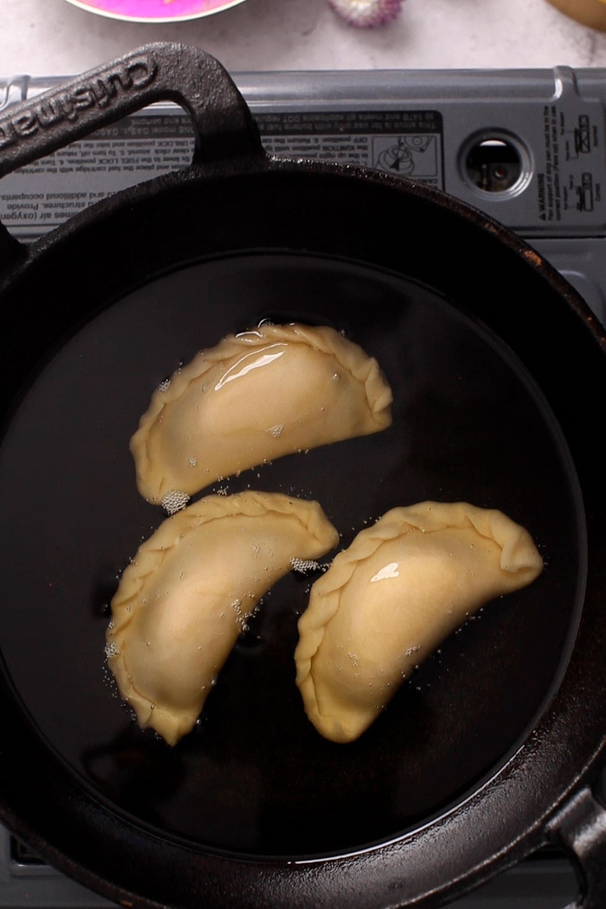 Gujiya are added to oil for frying.