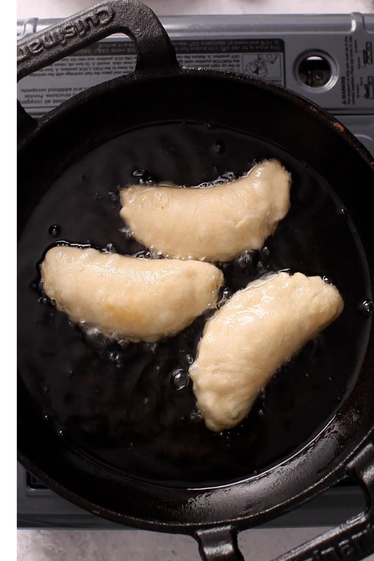 Gujiya is flipped while deep frying.