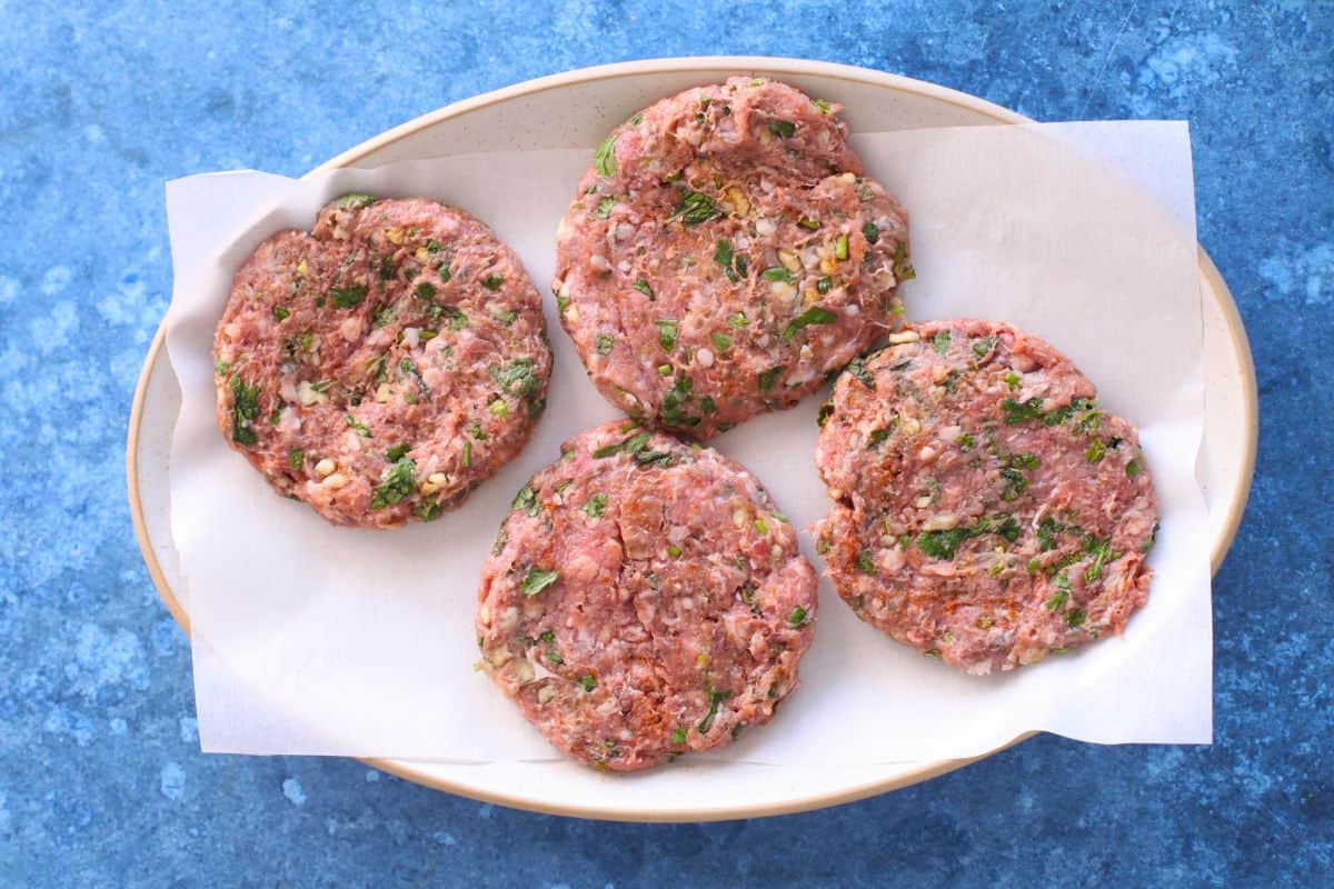 Lamb patties placed on a oval plate.