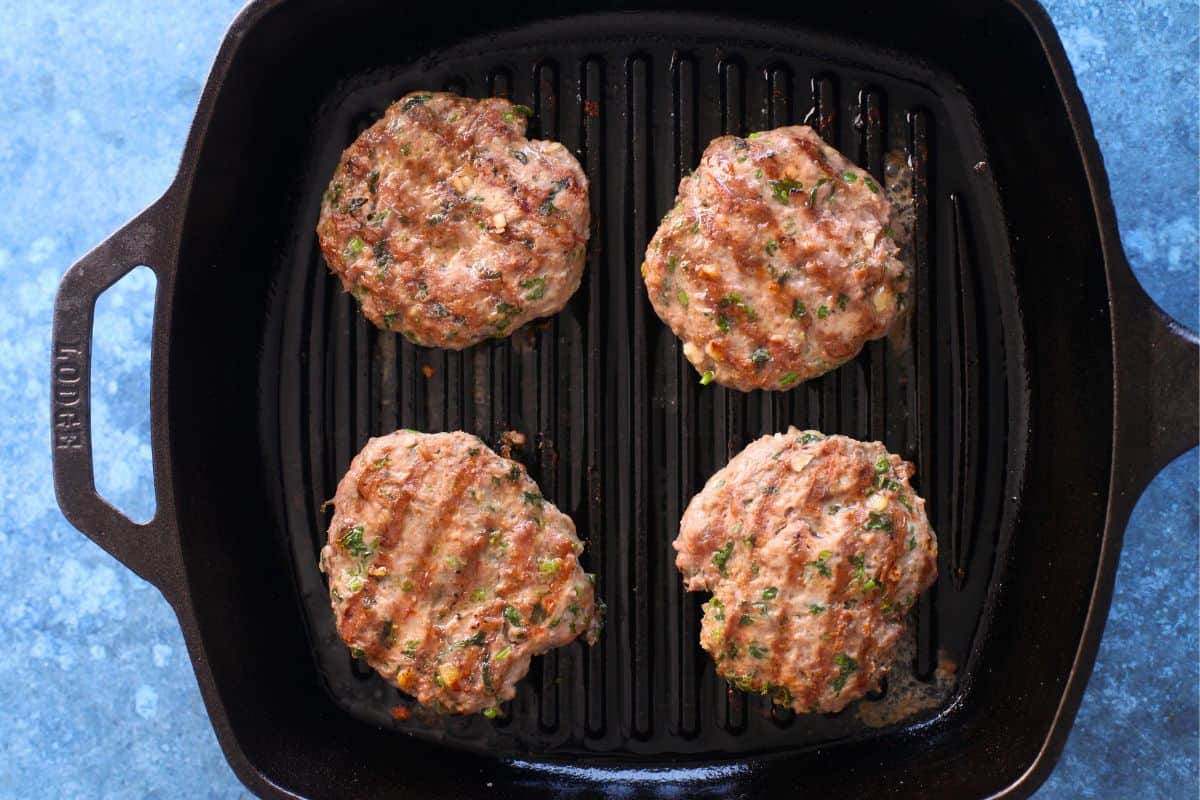 Grilled Lamb patties on a cast iron grill pan.