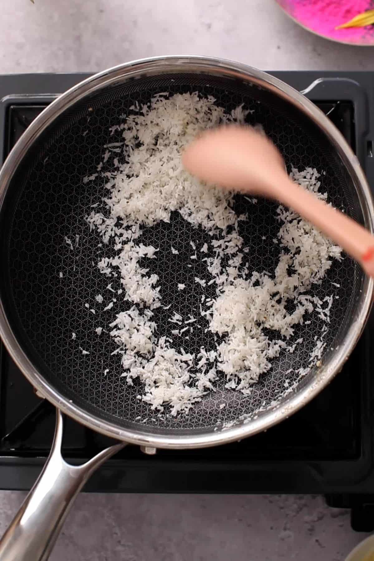 Dessicated coconut roasting in ghee.