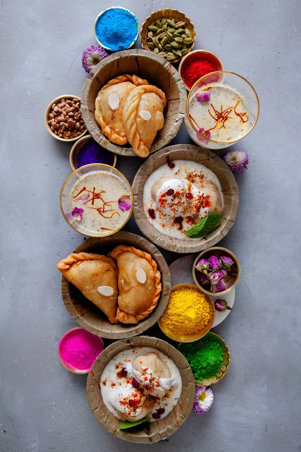 Holi Spread with gujiya, thandai and dahi vada along with holi colors.