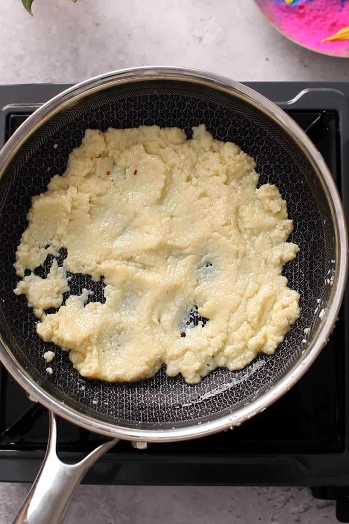 Softened mawa in a black pan.
