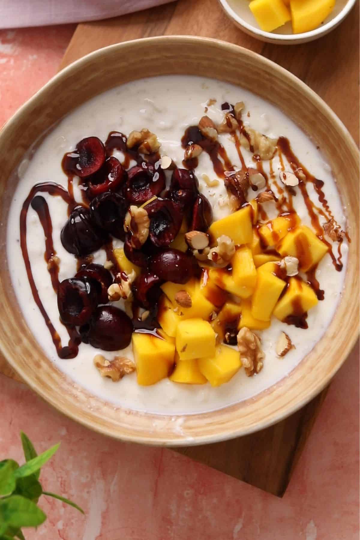 Dahi poha is topped with mangoes and cherries.