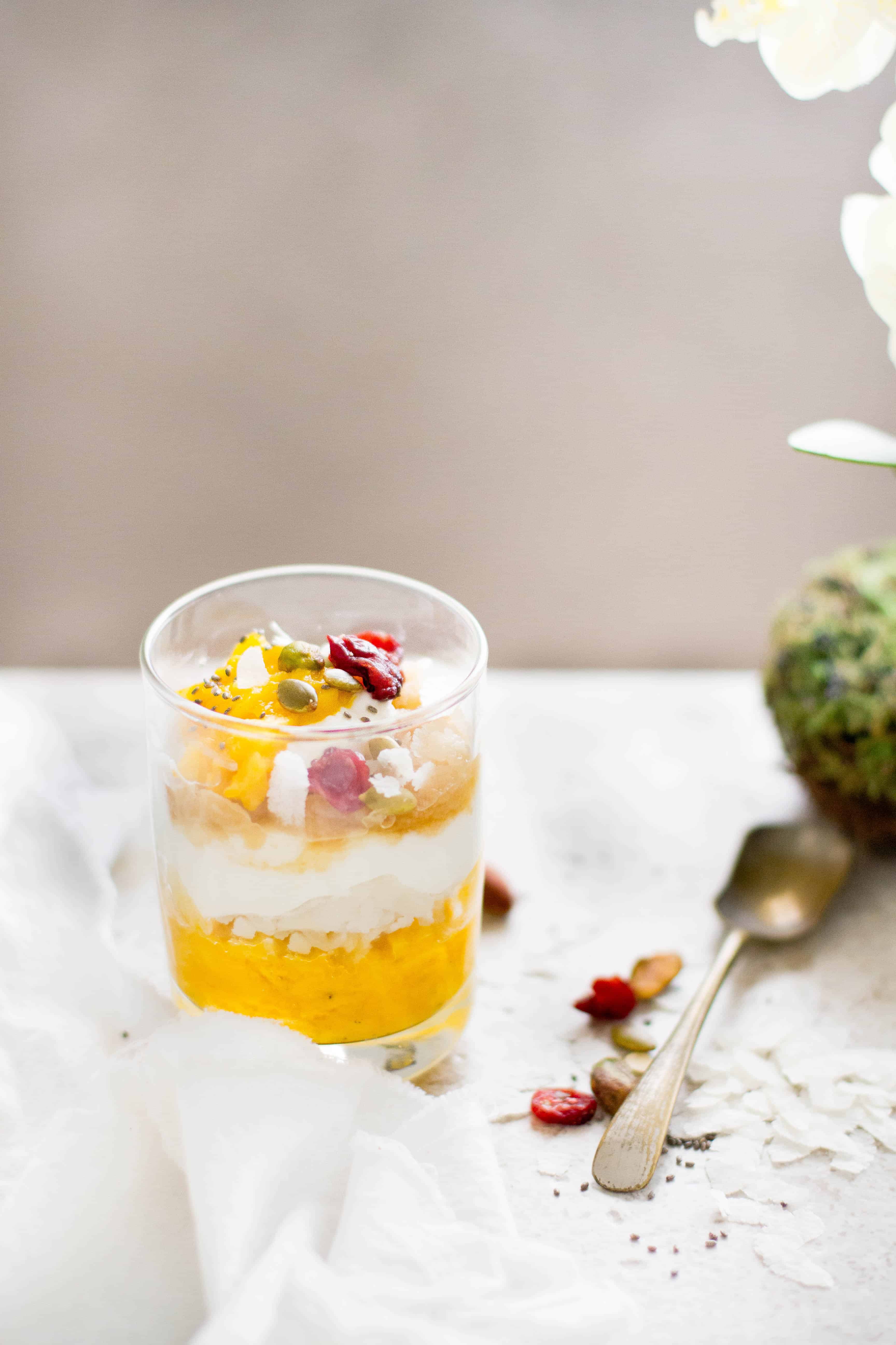  No Cook Flattened Rice & Yogurt Breakfast With Mangoes & Cardamom in a glass cup.