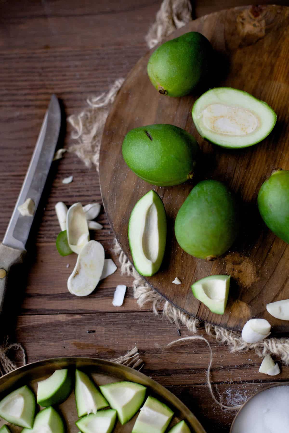 Raw mango pieces on a brown cutting board.