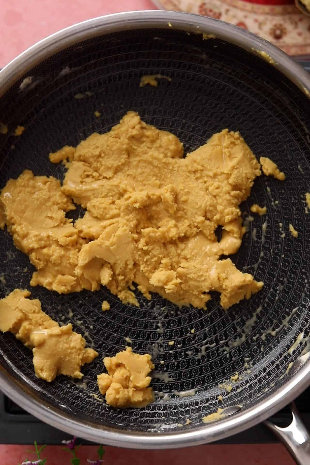 Besan and ghee mixture is looking thick and resembles wet sand.