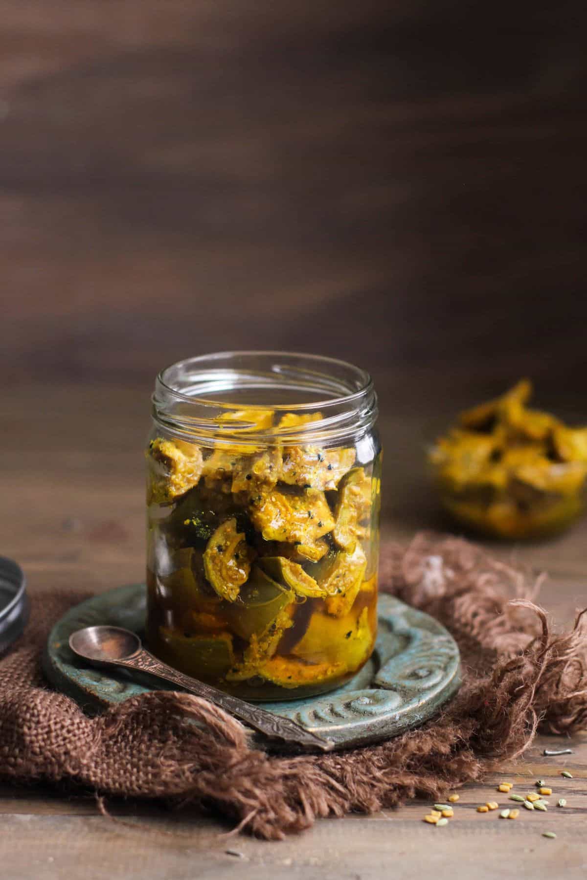 Aam ka Achar in a clear glass jar.