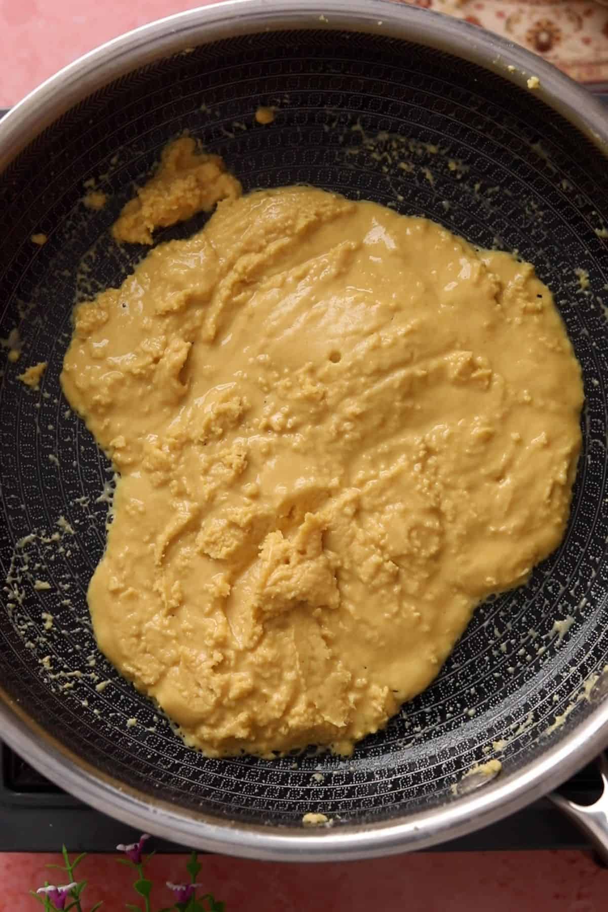 Besan and ghee mixture starts heating up and spreading.