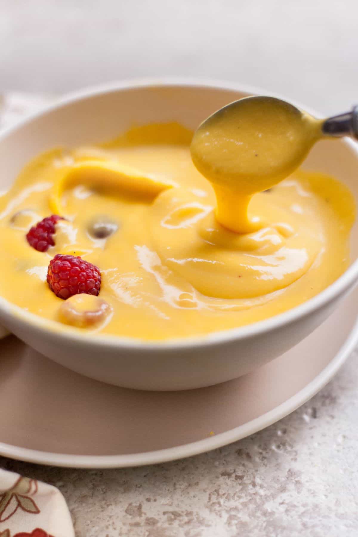 Image showing velvety ribbon like consistency of mango custard.