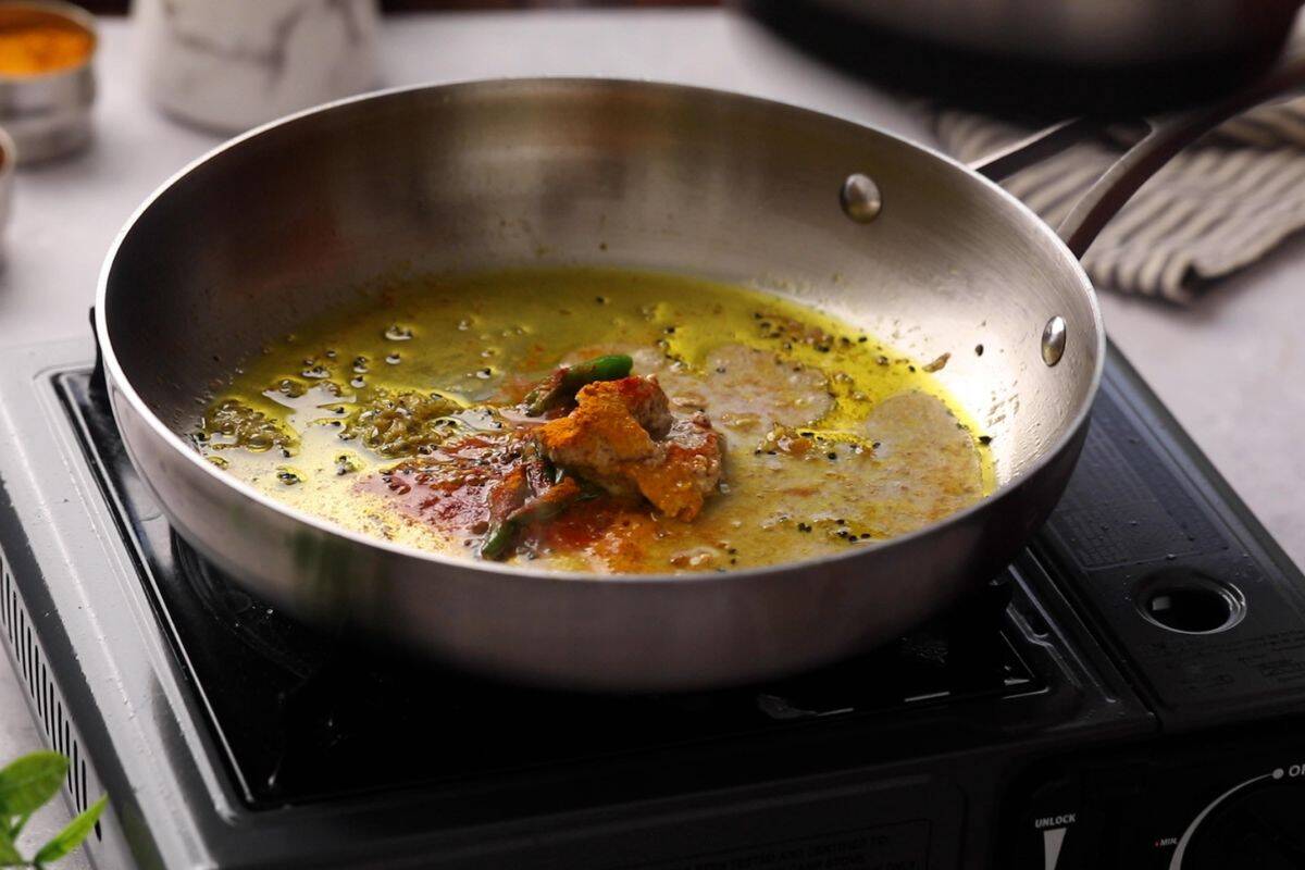 Mustard paste, spices are added to hot oil.