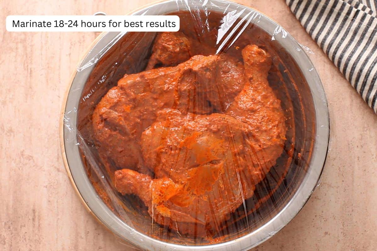 Chicken is left to marinate after covering the bowl with cling film.