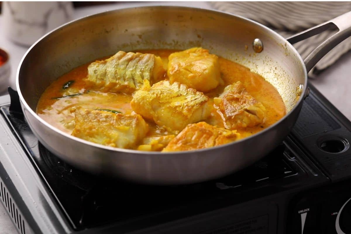 Water is added to mustard masala and cod is added back.