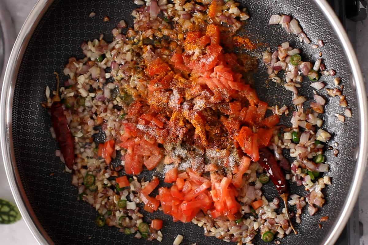 Chopped tomatoes and spices are added to the tadka.